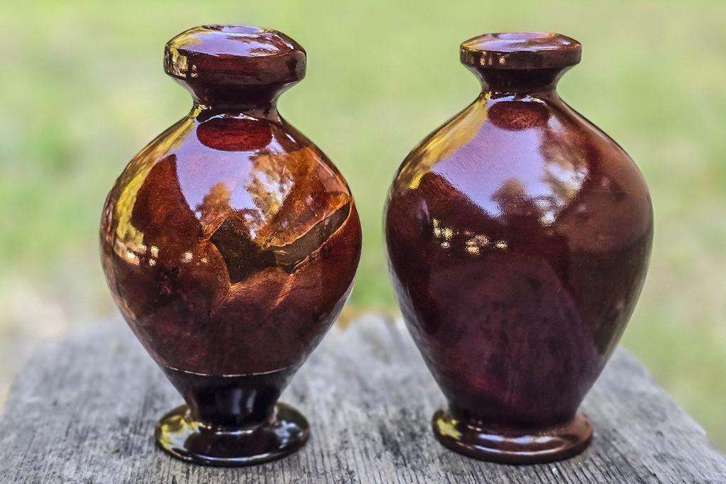 Two glossy dark red wood vases, slightly different d...